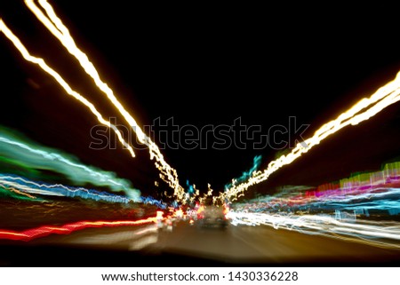 Long exposure.Colorful bokeh with street lights at night,motion movement with traffic lighting in the city on car windshield view,blur background.Speed fast with driving car. Abstract Background.