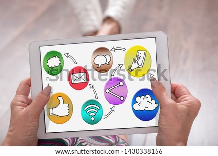 Social media concept shown on a tablet held by a woman