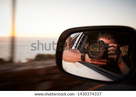 Man With Camera Taking Photo In Car Wing Mirror