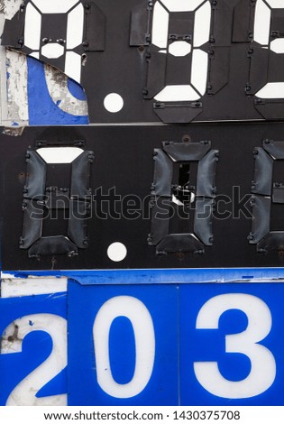 Numbers on the information board. Metal surface with mechanically movable covers.