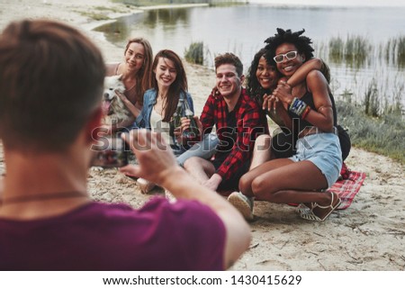 Sincere smiles. Group of people have picnic on the beach. Friends have fun at weekend time.