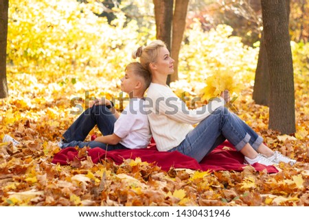 Mom with her son in the autumn park. Autumn park. Mom and son rest in the park.