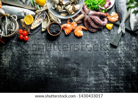 Seafood with herbs, tomatoes and lemon. On dark rustic background