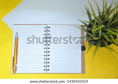 Layflat view office concept with blank notepad on minimalist background.