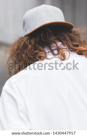 back view of man with curly hair in cup and white shirt