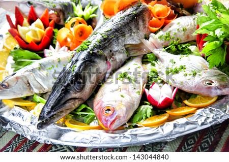 Picture of different sea fish plate arranged with vegetables.
