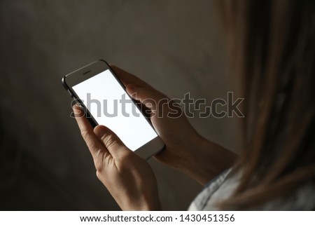 Woman using smartphone in dark room, closeup with space for text. Loneliness concept