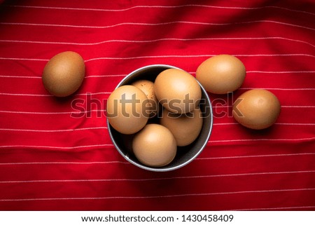 old wooden table where a brass pot with eggs is located