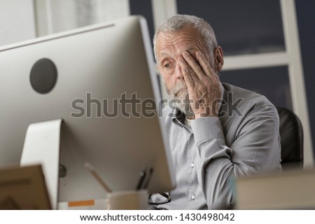 Confused senior citizen using a computer, he is staring at the screen and feeling tired and clueless, technology and elderly concept Royalty-Free Stock Photo #1430498042
