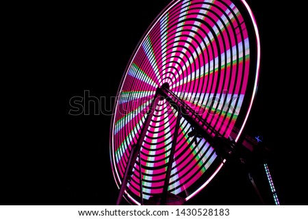 Spinning pink ferris wheel at fair night
