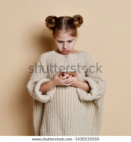 Little 7 years disappointed Girl Using Cell Smart Phone, Small Kid Happy Smiling Child Isolated Over pink Background