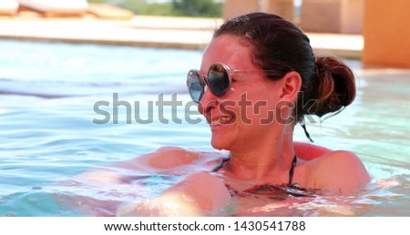 Happy woman at the swimming pool relaxing enjoying summer vacation real life smile and laugh