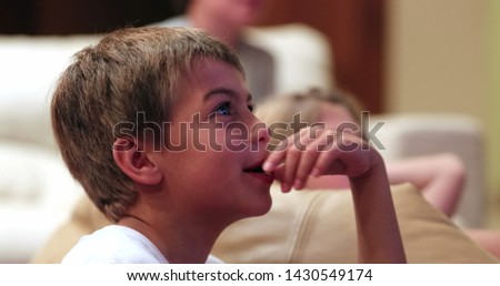Children in front of TV screen at living room watching movie