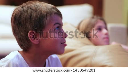 Children in front of TV screen at living room watching movie