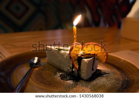 A piece of cake with candles for birthday with oranges