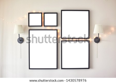 Different size framed photos hanging on the grey wall.
