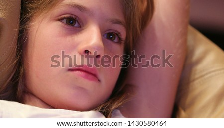 Child closeup face expression watching movie screen learning about story