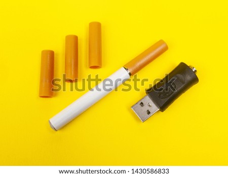 Closeup photo of an electronic cigarette on yellow background.