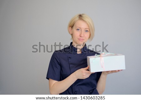 Portrait of a young female cook over dark background.