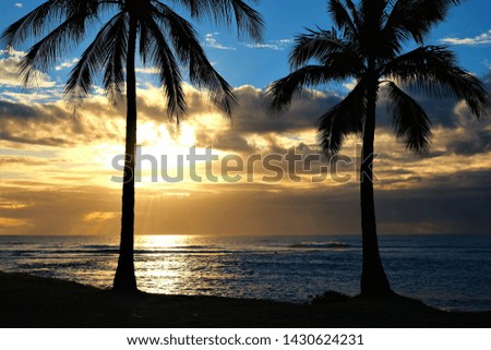 Golden sunset and twilight on the West side of Oahu Hawaii.  Photos include palm trees, pacific ocean, reef and layers of clouds.