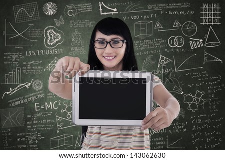 Beautiful female student is showing blank screen of e-tablet in class