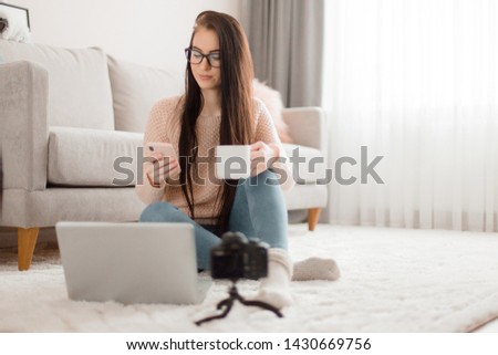 Young trendy woman blogger in cute pink girl room