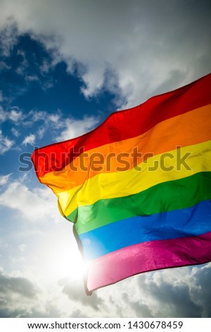 Close-up of gay pride rainbow flag fluttering backlit in bright sunny sky