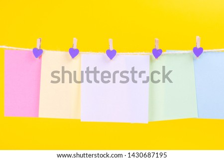 Colorful paper cards hanging rope isolated on yellow background. Place for your text.