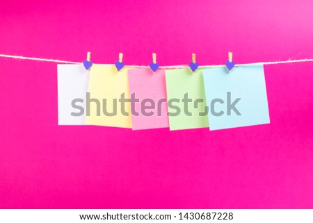 Colorful paper cards hanging rope isolated on hot pink background. Place for your text.