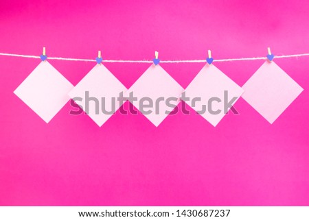 Pink stickers on clothesline with clothespins isolated on hot pink background. Place for your text.