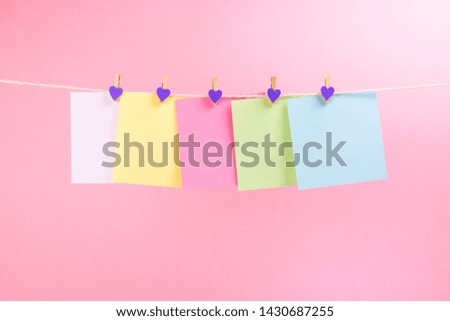 Colorful paper cards hanging rope isolated on pink background. Place for your text.