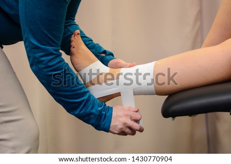 Ankle tape job for support and stability Royalty-Free Stock Photo #1430770904