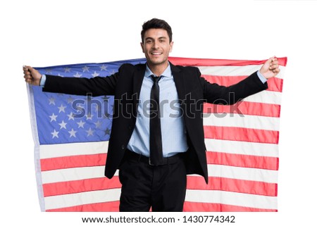 Smiling Caucasian businessman standing and holding  an American flag isolated on white background.