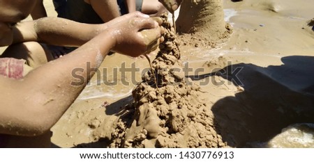 children play sand by making a building on the beach