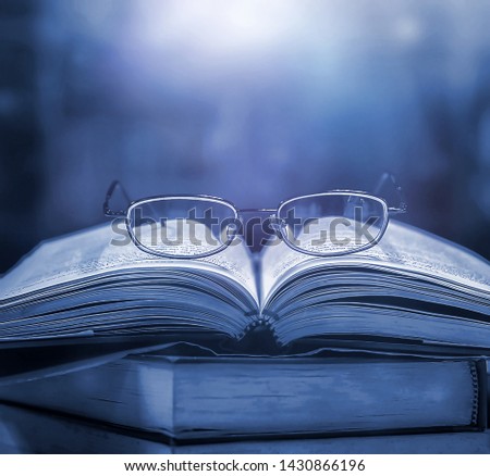 Imagine opening a magic book with bright white light and softness on a wooden table with a blurred bookshelf. Fantasy magic For wallpapers, beautiful computer screen wallpapers