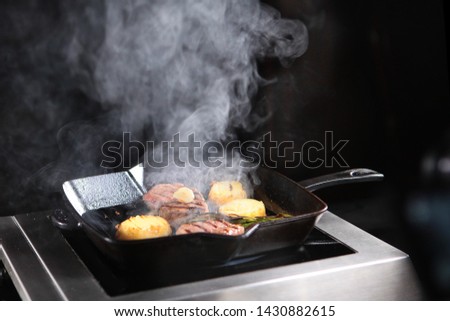 Vegetables and meat pieces are cooked on a grill pan. Filet mignon is a delicious meat dish. Beef tenderloin. The concept of cooking vegetables and grilled meat indoors.Photo indoors.