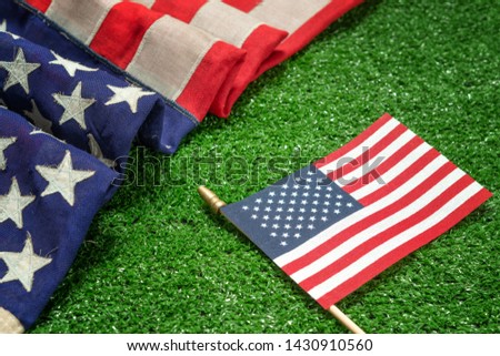Red, white, and blue American flag on grass for Memorial Day or Veteran's day background