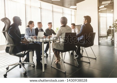 Silhouettes of people sitting at the table. A team of young businessmen working and communicating together in an office. Corporate businessteam and manager in a meeting Royalty-Free Stock Photo #1430938028