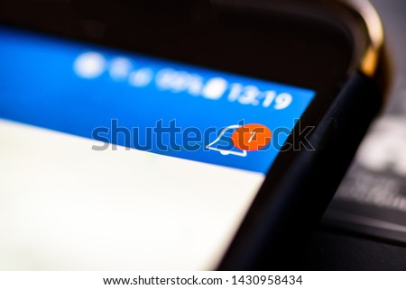 Notification bell button on smartphone app screen closeup Royalty-Free Stock Photo #1430958434