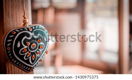 Love concept with decorative heart hanging and unfocused house background
