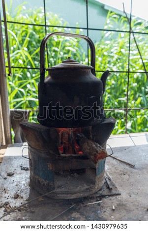firewood and kettle beside stove, objects in kichenette
