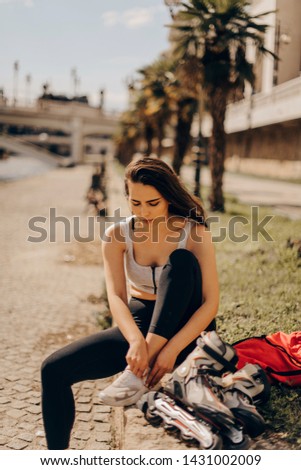 Girl going rollerblading sitting putting on inline skates