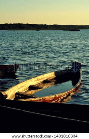 Romantic wooden yellow boat on the river with water inside.