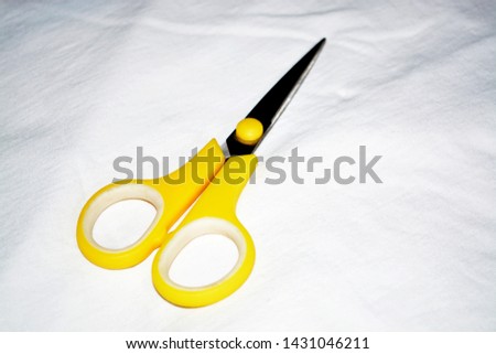 Yellow scissors isolated on a white background