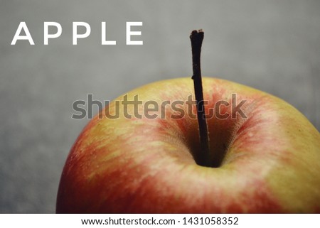 Fresh red apple. Juicy fruit. The inscription on the pictures of an apple. Fruit background. Apple closeup isolated on a black and grey background.