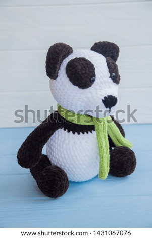 
Crocheted funny black and white panda in a scarf