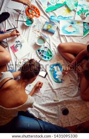 Group of young people painting with temperas