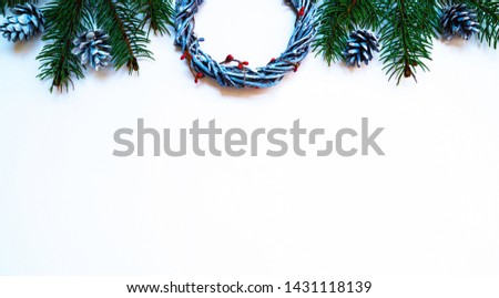 Christmas composition. Wreaths, red berries, fir branches and pine cones on pastel gray background. Christmas, winter, new year concept. Flat lay, top view, copy space.