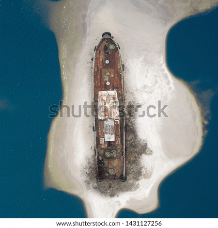 old broken ship stay on small island of sand 