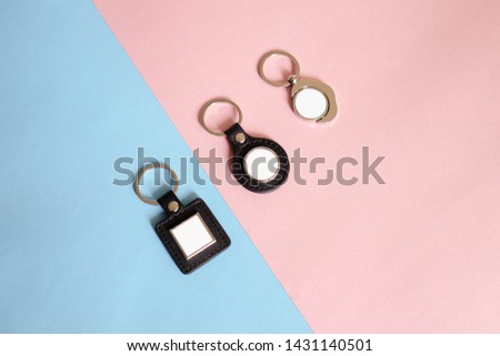 Top view :Blank metal round black and blank square PU leather black color key chain mock up realistic. Isolated souvenir template for image or text inside on pastel pink and blue colorful background.